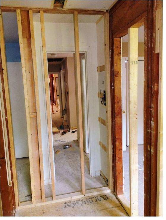 Interior doorway opening framed in new lumber during a remodel, with subfloor exposed.